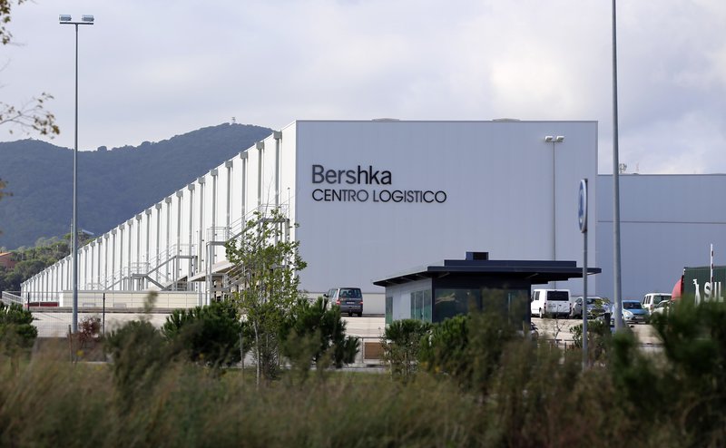 Palafolls. Polígon industrial Mas Puigvert. Empresa Bershka des de fora. Davant hi estan habilitant una altra nau de color vermell, crec . Fotos de les dues empreses